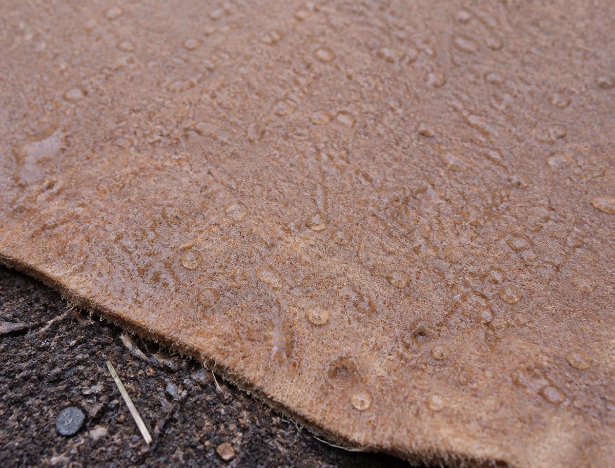 Macro shot of the wet mulch fabric holding moisture against soil